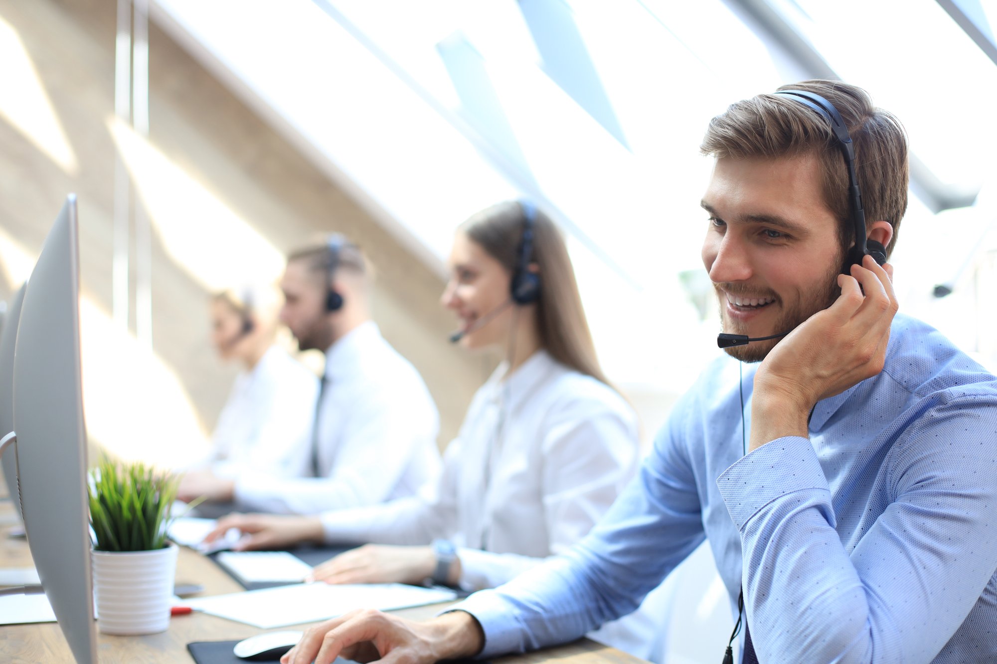 portrait-call-center-worker-accompanied-by-his-team-smiling-customer-support-operator-work